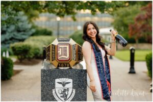 College Graduates Holding Champagne next to Ring on Duquesne University Campus in Pittsburgh