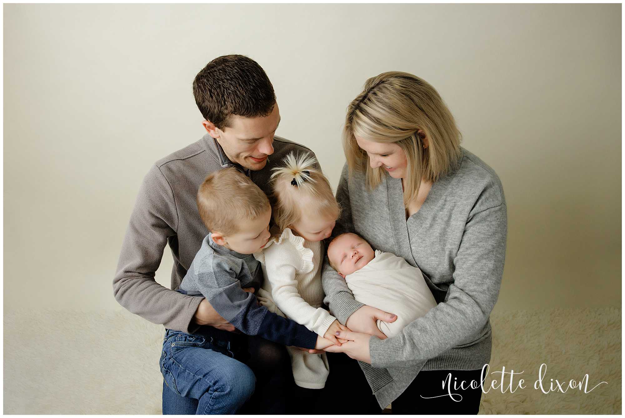 Family looking at newborn baby in studio in North Fayette Township near Pittsburgh.