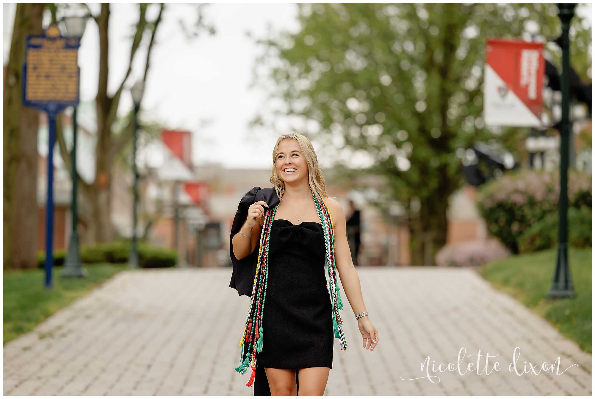 College grad walking with gown over shoulder at Washington and Jefferson College near Pittsburgh